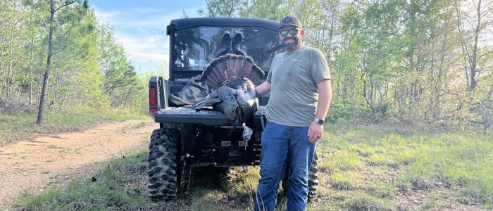 Turkey hunter beside a utility vehicle Turkey hunter beside a utility vehicle